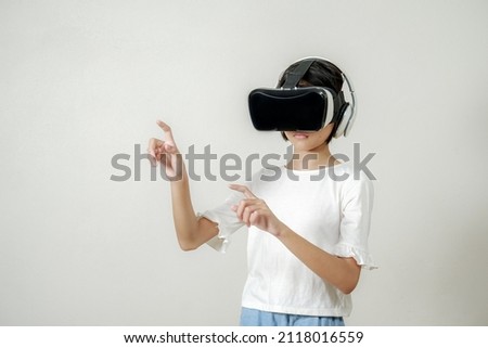 VR application test Asian child girl with virtual reality glasses headset touching air during the VR experience, asia children and learning with virtual reality simulator application test