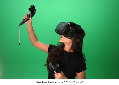 VR girl playing with virtual relaity headset isolated on green screen background. Virtual Reality emotions by games for Black hair young girl