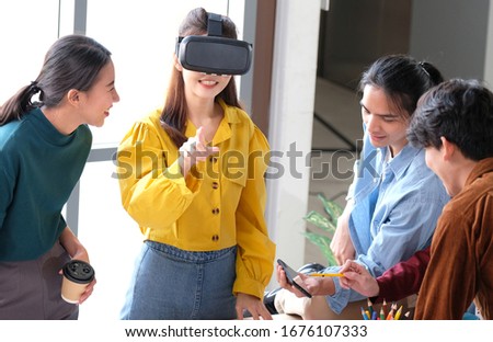 VR mobile phone application test, Asian woman with virtual reality glasses headset touching air during the VR experience, Young asia developers meeting for reality simulator smartphone appl test