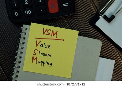 VSM - Value Stream Mapping Write On Sticky Notes Isolated On Wooden Table.