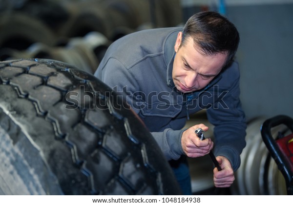 vulcanizing\
shop worker separating the tire from the\
rim
