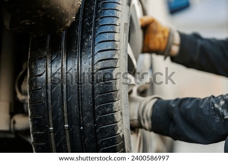 Vulcanizing worker's hands changing tire.