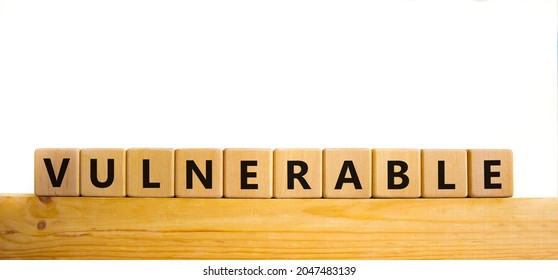 Vulnerable Symbol. The Word Vulnerable On Wooden Cubes. Beautiful Wooden Table, White Background. Business And Vulnerable Concept. Copy Space.