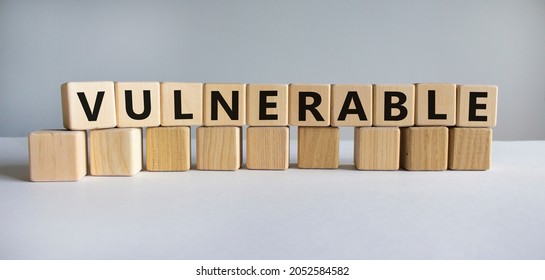 Vulnerable Symbol. The Word Vulnerable On Wooden Cubes. Beautiful White Table, White Background. Business And Vulnerable Concept. Copy Space.