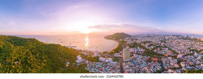 Vung Tau city aerial view with beautiful sunset and so many boats. Panoramic coastal Vung Tau view from above, with waves, coastline, streets, coconut trees and Tao Phung mountain in Vietnam. - Powered by Shutterstock