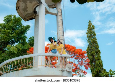 VUNG TAU CITY, VIETNAM - JULY 12, 2020:  a group of friends standing under Poinciana tree, full of red flowers on blur background  - Shutterstock ID 1835103898
