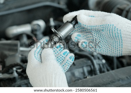 The VVT-i system (Variable Valve Timing intelligent — valve timing changes).A new VVT-I valve is in the hands of an auto mechanic. A specialist checks the serviceability of a new spare part.