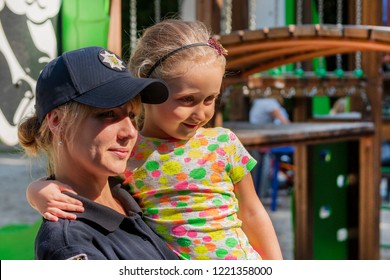 Vynnytsa. Ukraine. 09.15.2018. The Smiling Woman The Policeman Holds On Hands Of The Happy Child. Portrait Of The Police Officer And Child. The Concept Police Loves Children.