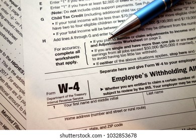 W-4 form and a pen. Tax season - Shutterstock ID 1032853678