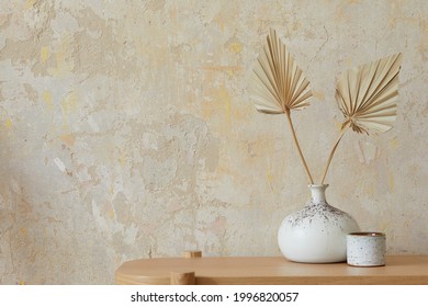 Wabi sabi interior of living room with wooden console, paper flowers in vase, accessories and copy space. Minimalistic concept. Template.