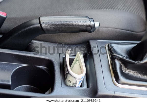 A wad of dollars inside the car. A wad of dollars\
inside the car.