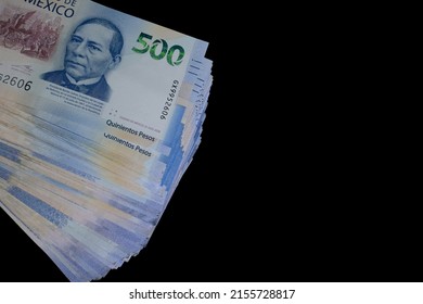 wad of Mexican banknotes on black background. copy space. 500 mexican pesos bills.