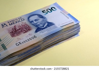 wad of Mexican banknotes on yellow background. copy space. 500 mexican pesos bills.