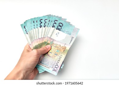 Wad of money in hand isolated on white background. Banknote of one hundred Belarusian rubles. Minimal salary. Living wage budget. Close-up. Offline payments. Cash payment. Financial credit. Inflation.