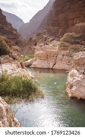 Wadi Ash Shab Pools and Cave / Oman - February 12, 2020: tourists enjoying in the water of Wadi Ash Shab