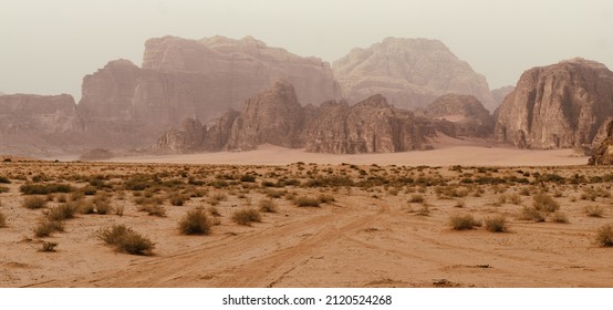 Wadi Rum desert, Jordan, The Valley of the Moon. Orange sand, haze, clouds. Designation as a UNESCO World Heritage Site. National park outdoors landscape. Offroad adventures travel background.
				