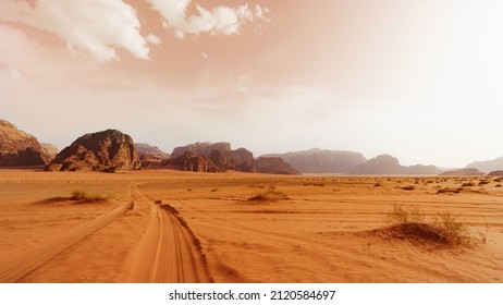 Wadi Rum desert, Jordan, The Valley of the Moon. Orange sand, haze, clouds. Designation as a UNESCO World Heritage Site. National park outdoors landscape. Offroad adventures travel background. - Shutterstock ID 2120584697