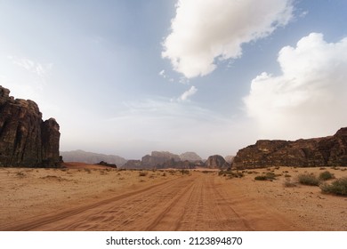 Wadi Rum desert, Jordan, The Valley of the Moon. Orange sand, haze, clouds. Designation as a UNESCO World Heritage Site. National park outdoors landscape. Offroad adventures travel background.
