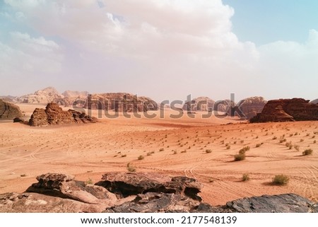 Wadi Rum desert, Jordan,  The Valley of the Moon. Orange sand, haze, clouds. Designation as a UNESCO World Heritage Site. National park outdoors landscape. Offroad adventures travel background.       