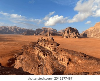 Wadi Rum desert in Jordan with vast red sands, towering sandstone cliffs, and a clear sky highlighting the unique rock formations. - Powered by Shutterstock