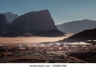 Wadi Rum Desert (Valley Of The Moon) With Bedouin Camps And  Bubble Tents In Dusty Day, Jordan. Arabian Desert.