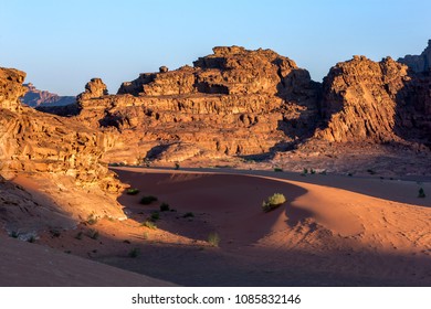 WADI RUM, JORDAN - JUNE 13, 2014 : The Sun Begins To Rise Over A Section Of The Desert Landscape At Wadi Rum In Jordan.