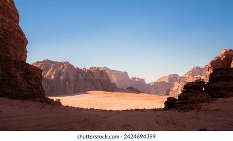 Wadi Rum, Jordan, Scenic view of Arabic Middle Eastern desert against clear blue sky with sand tracks in foreground. Mountain in background. Copy space no people. Landscape horizontal - Powered by Shutterstock