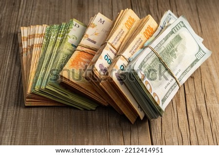 wads of money in dollars and Argentine pesos