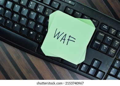 WAF - Web Application Firewall Write On Sticky Notes Isolated On Wooden Table.