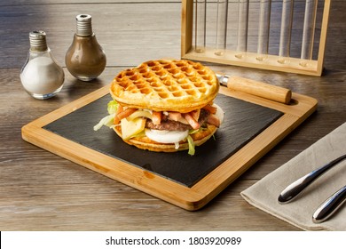 Waffle burger with bacon, Roblochon cheese, onions and salad