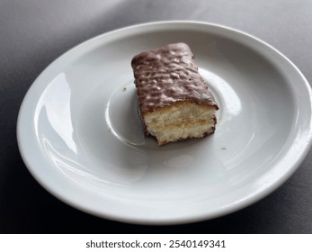 Waffle chocolate bar bitten on small white plate isolated on black background - Powered by Shutterstock