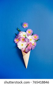 Waffle cone with chamomile flower bouquet on blue background. Flat lay, top view floral background. – Ảnh có sẵn