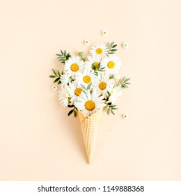 Waffle Cone With Chamomile Flower, Leaves On Beige Background. Flat Lay, Top View Floral Background.