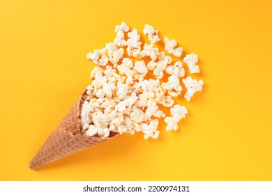 Waffle Cone With Salted Popcorn On Yellow Background. Snack Concept