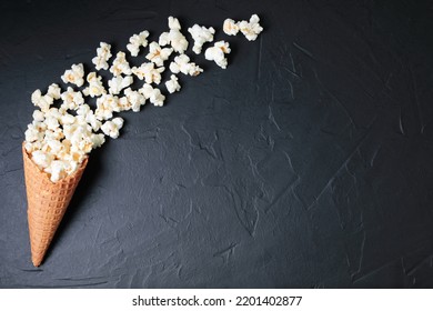 Waffle Cone With Salted Popcorn On Black Concrete Background. Snack Concept Close-up