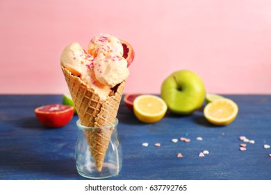 Waffle Cone With Tasty Ice Cream And Sprinkles In Jar On Wooden Table