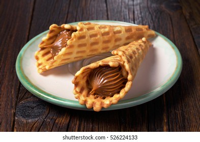 Waffle Cones With Condensed Milk Are In The Plate On Dark Wooden Table