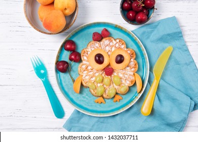 Waffle with fruits and berries in the shape of cute owl with balloons, food for kids idea, top view