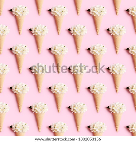 Waffle ice cream cone with jasmine flowers on a pink background. Summer concept