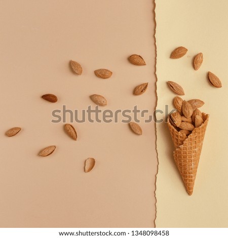 Similar – Ice cream cone with unpeeled peanuts on pink background