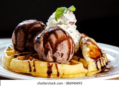 Waffle topped with chocolate ice cream , banana and wipe cream