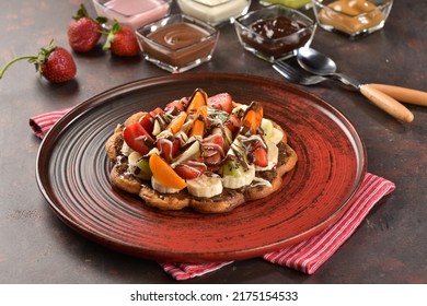 Waffle with whipped cream, banana, apricot, strawberry and Belgian chocolate. Delicious waffle. Concept picture. Top view of waffle with ingredient. Presentation of waffle. 