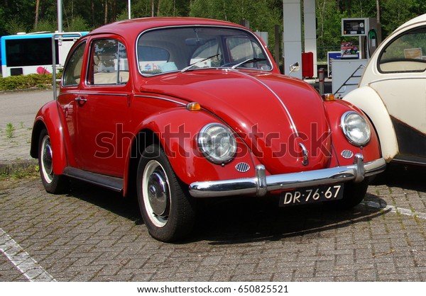 Wageningen, The Netherlands - May 29, 2017: Red\
Volkswagen Type 1 parked on a public parking lot in the city of\
Wageningen. Nobody in the vehicle. The VW T1 is also known as\
Beetle, Bug and\
Kafer.