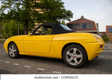 Wageningen, The Netherlands, May 7 2020:  Yellow Car convertible Fiat barchetta 1996, Side view of Classic and Sports auto