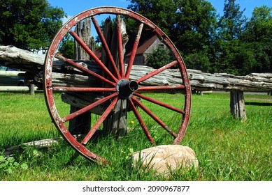 Wagon wheel against fence on farm on a sunny day
