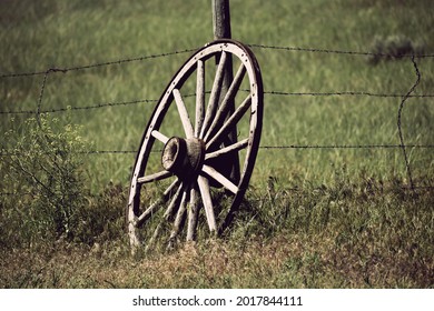 Wagon Wheel leaning against the barbed wire fence