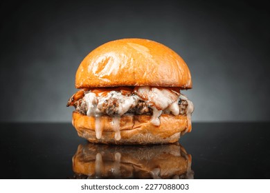 Wagyu and bacon cheese burger on dark background.