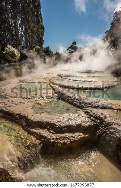 Wairakei Hot Spring Terraces and Hot Pools in\
New Zealand geothermal area near Lake Taupo. Cascade hot springs\
and pools of healing water with fog around. Thermal health spa.\
Silica terraces.