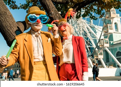 Waist Up Of Happy Old Man In Clown Dress Blowing Bubbles Stock Photo