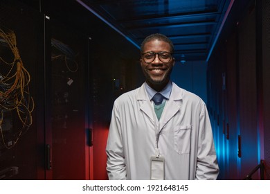 Waist Up Portrait Of African American Data Scientist Wearing Lab Coat And Smiling At Camera While Working With Supercomputer In Server Room, Copy Space